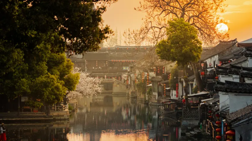 夕阳下西塘水巷、岸树与石拱桥