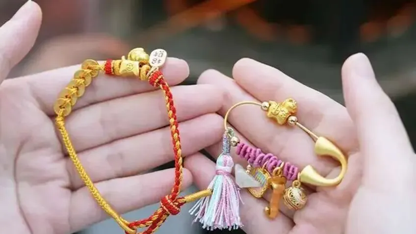 掌心红绳手串与金色祝福别针同展
