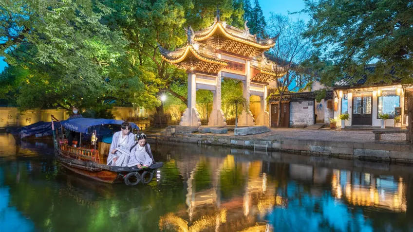 夜景牌坊下汉服游客坐摇橹船
