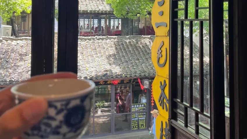 三毛茶楼窗边茶杯俯看街巷瓦顶