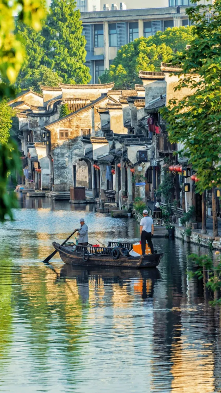 高处俯看临水民居与河中摇橹船
