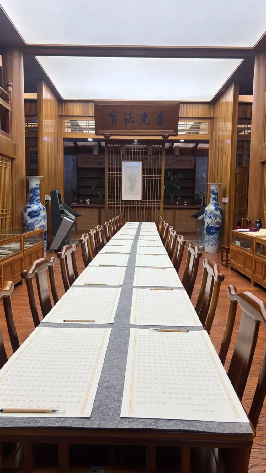 抄經廳長桌整齊擺放心經紙與毛筆
