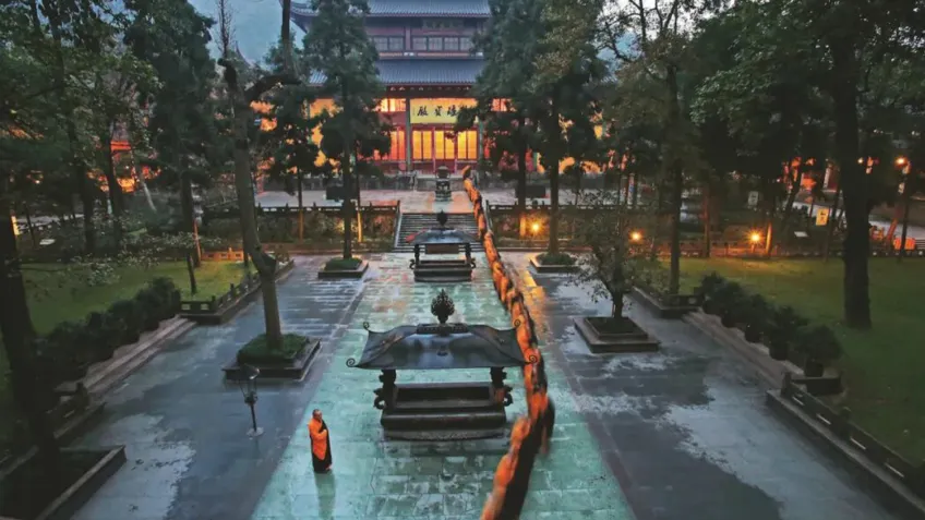 橙衣僧侣沿石板甬道走向大雄宝殿晨曦场景