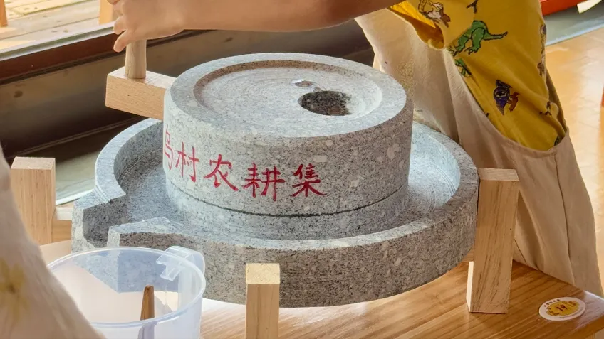 乌村石磨上手推磨制豆浆的场景