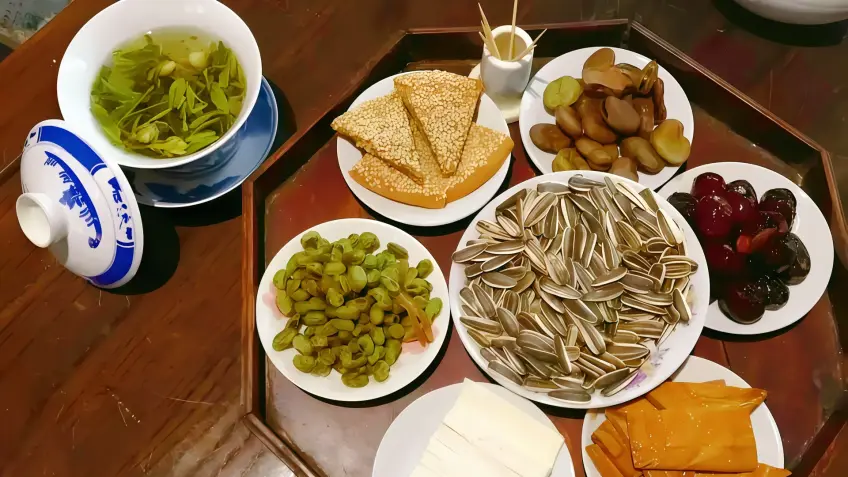 木桌上阿婆茶茶点拼盘与盖碗茶