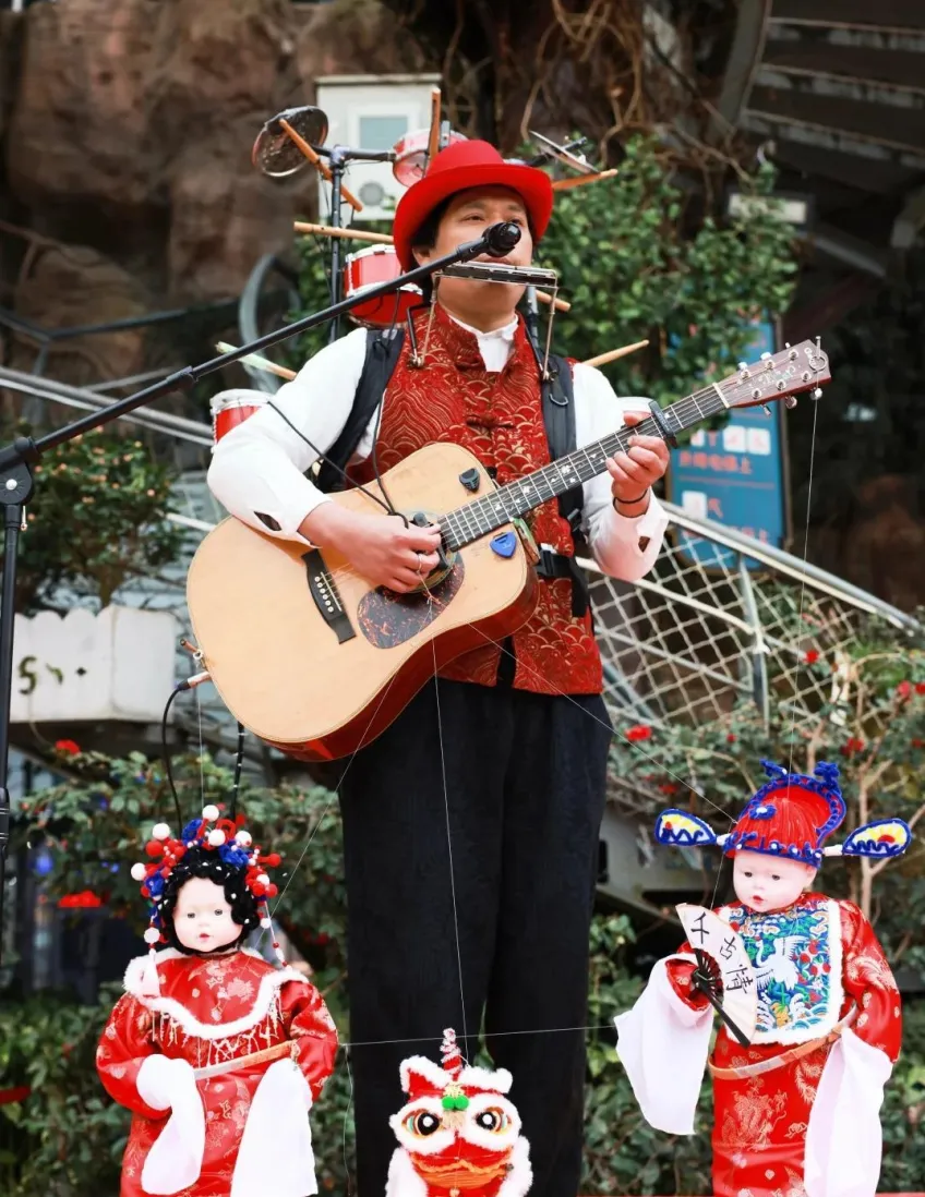 紅帽街頭藝人背鼓彈吉他與戲偶