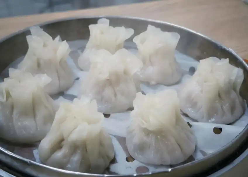金属笼屉中七只皮薄烧麦特写