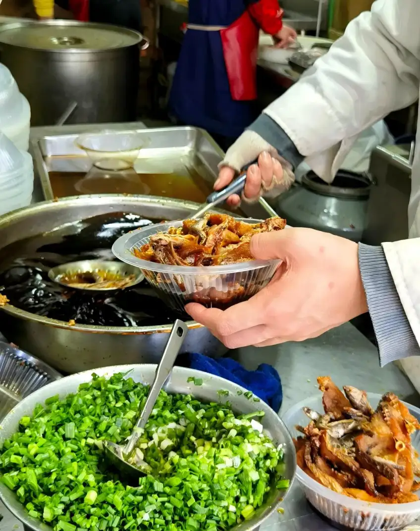 厨师将现炸酥鱼盛入酱汁盆