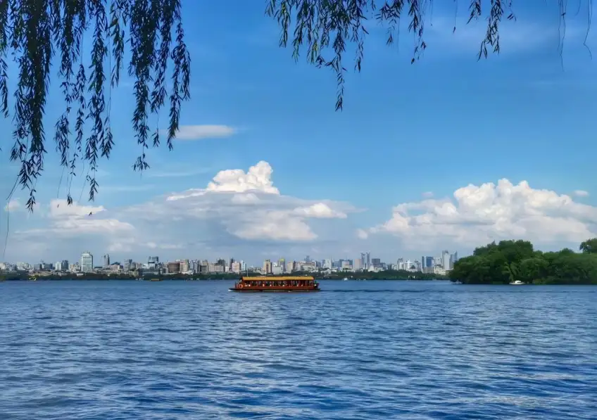 西湖柳枝下木船遊湖遠景