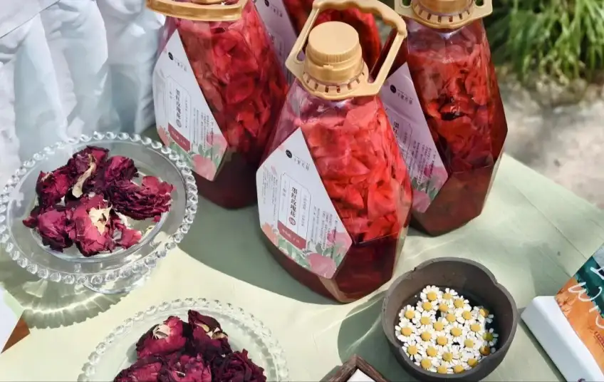 绿桌上玫瑰花醋瓶与玫瑰花蕾小碟