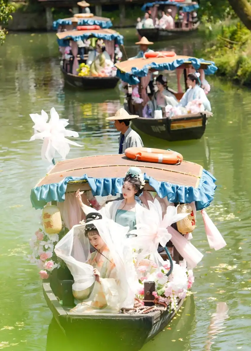 多艘花饰游船载汉服旅客驶过绿水道