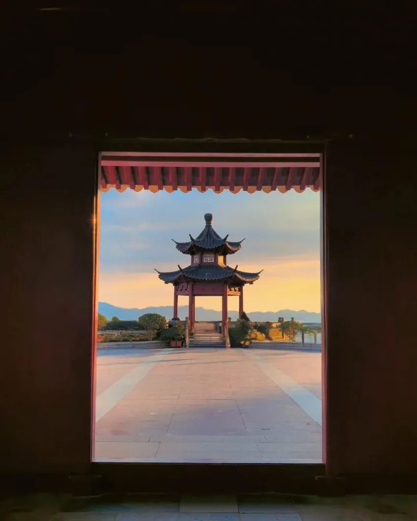 寺院门洞框景中的古亭与夕照