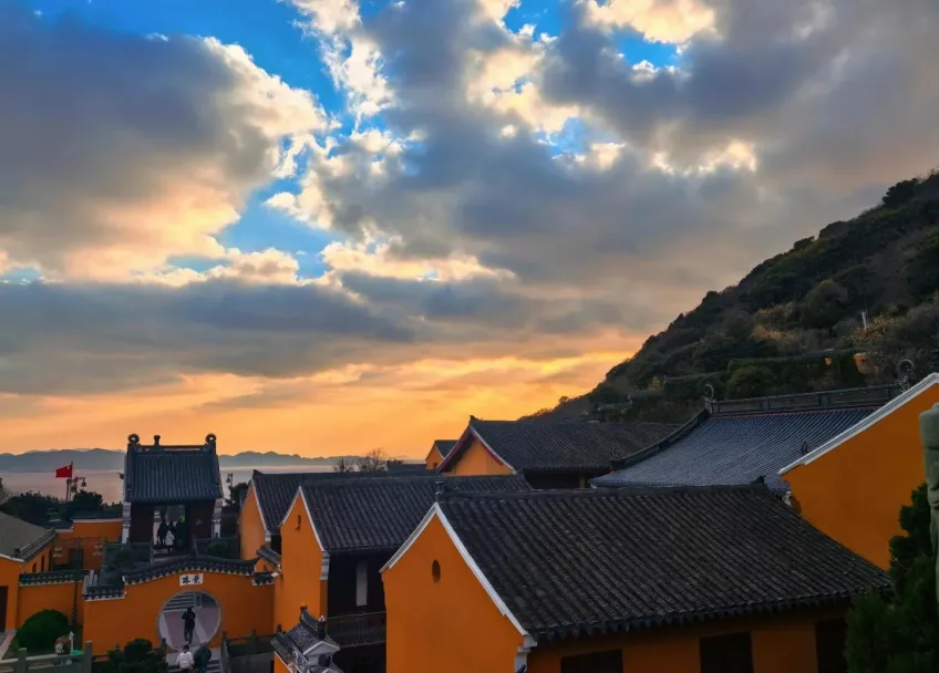 普陀山黄墙黛瓦寺宇远望海面与落日云霞