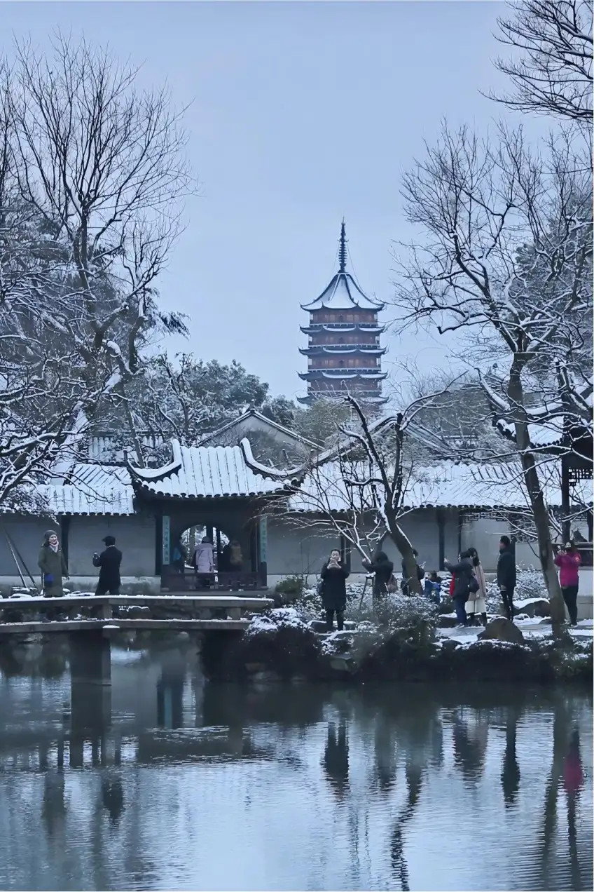 拙政园冬雪覆盖水阁瓦顶倒映静水