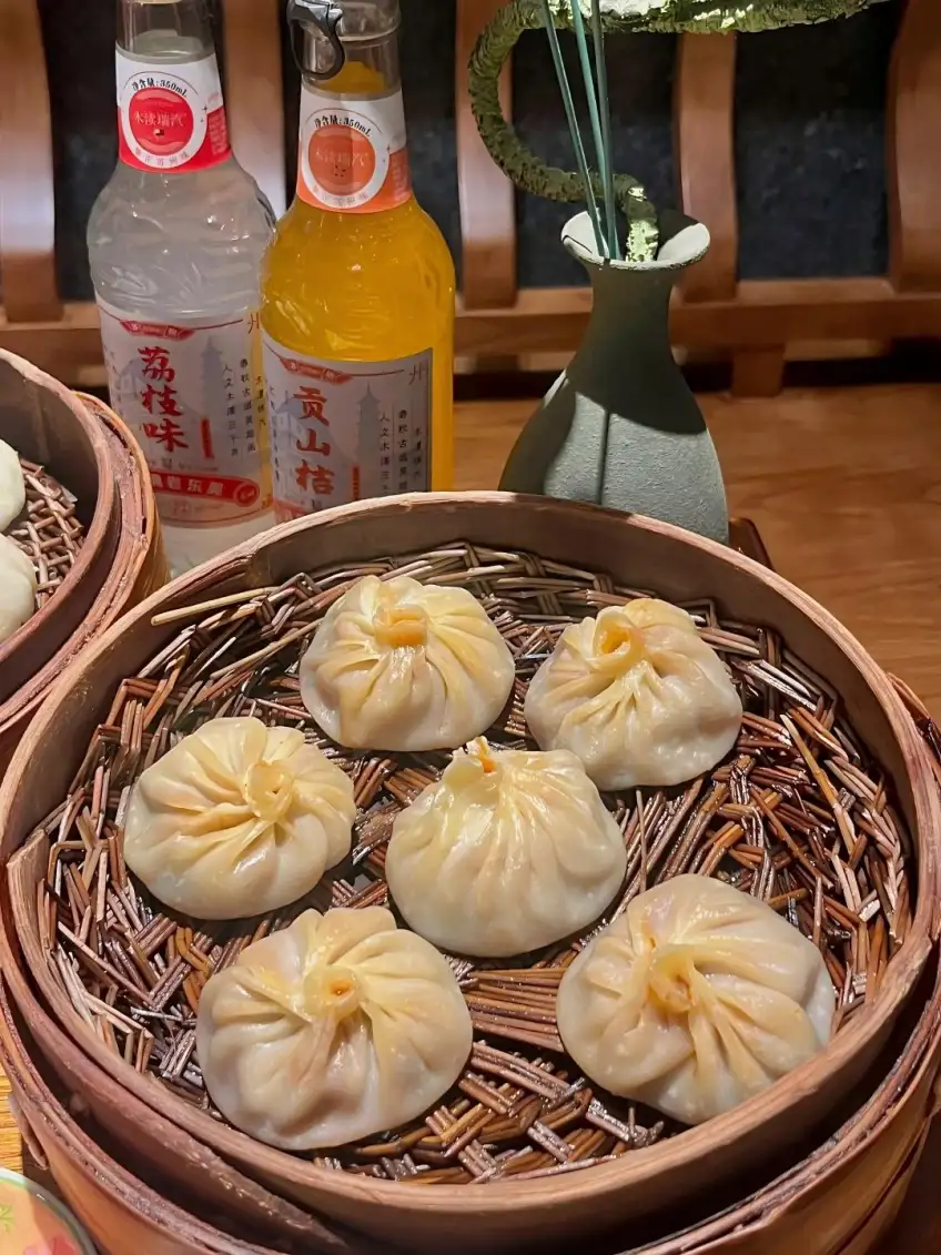 笼屉汤包旁荔枝味与桔子汽水