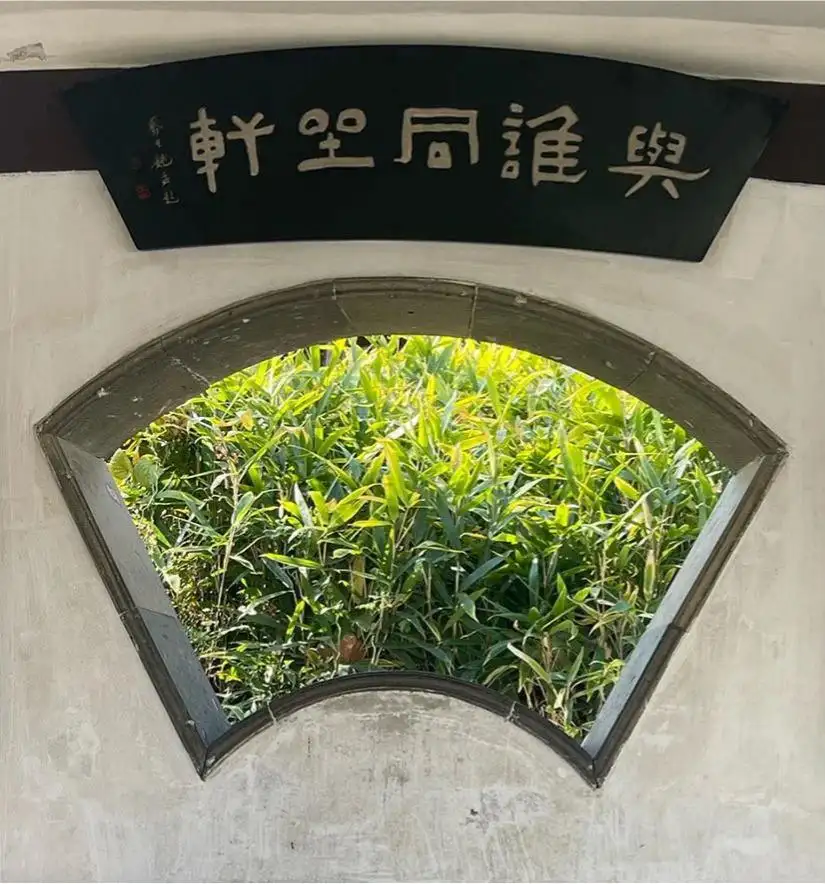 与谁同坐轩扇窗匾额后竹叶掩映