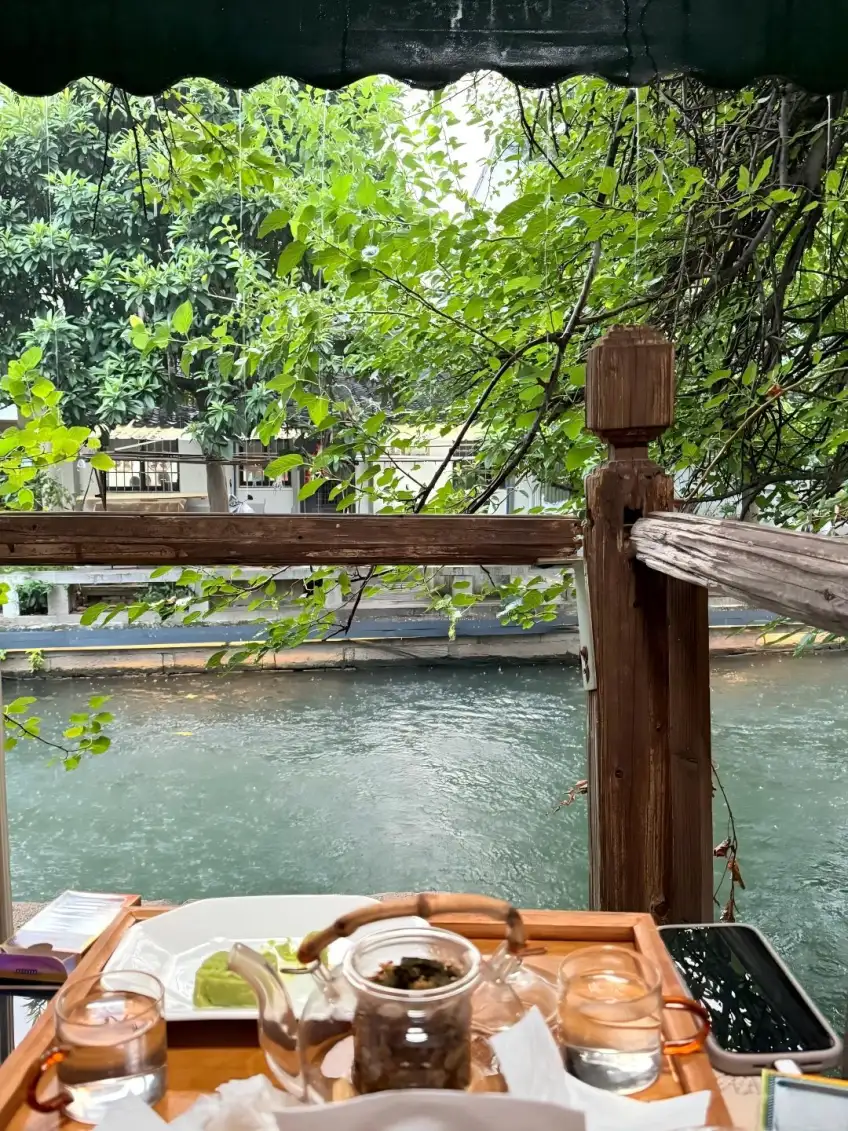 临水茶座玻璃茶壶点心与雨中河道