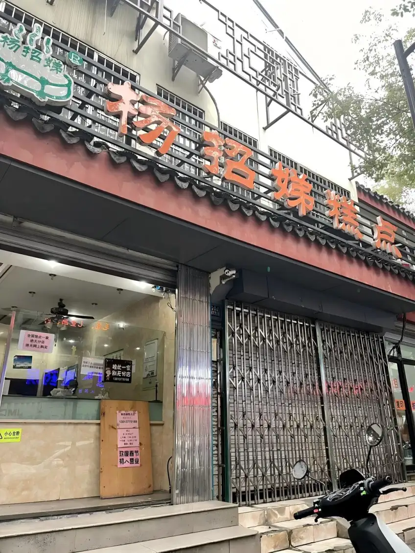 杨招娣糕点橙字招牌与卷帘门