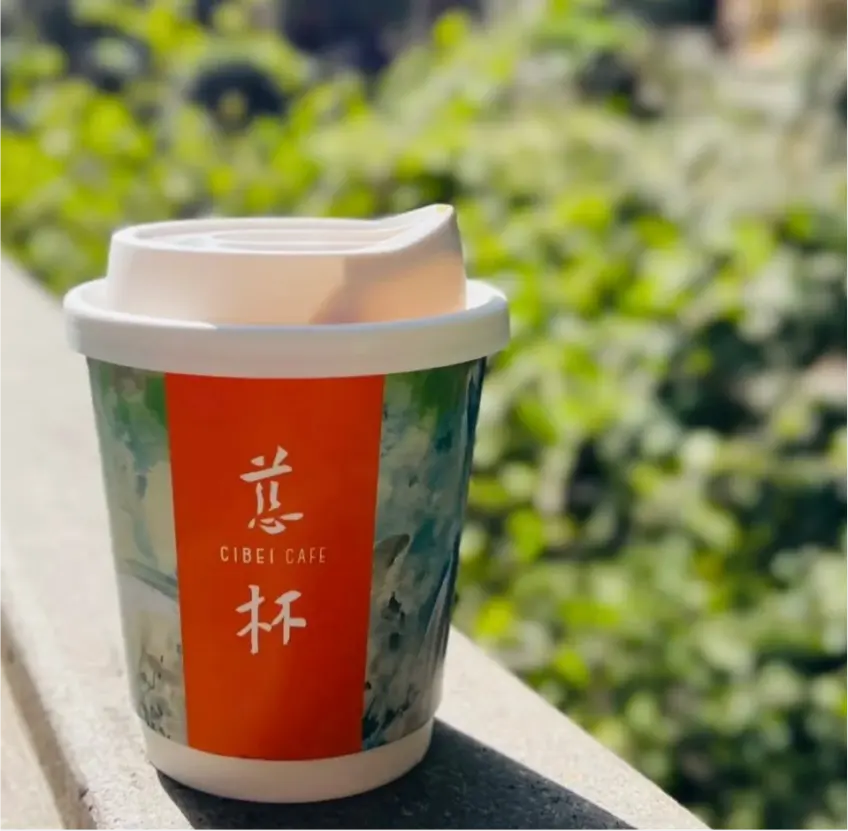 慈杯咖啡外带杯置于绿荫石栏