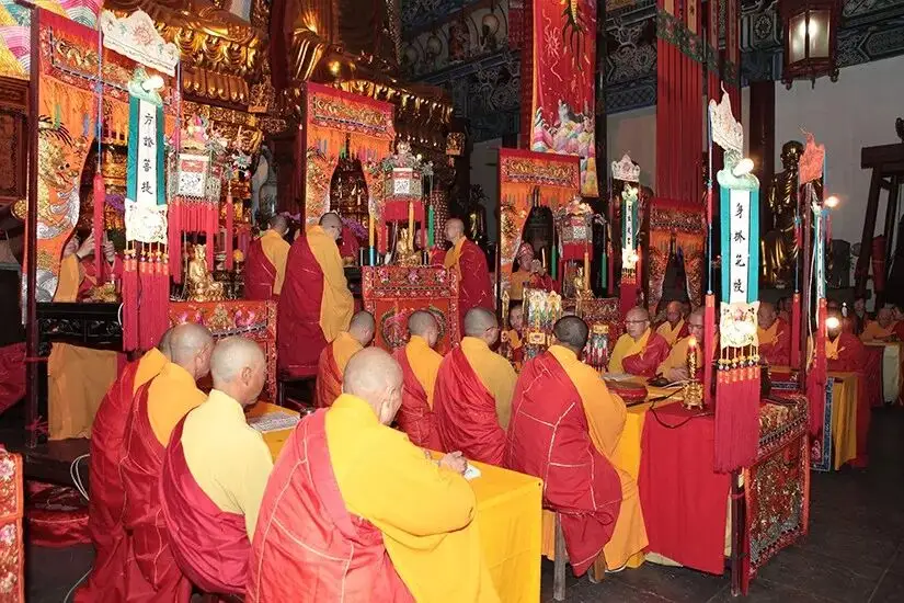 金山寺庙堂内僧众黄红袈裟围桌诵经法会