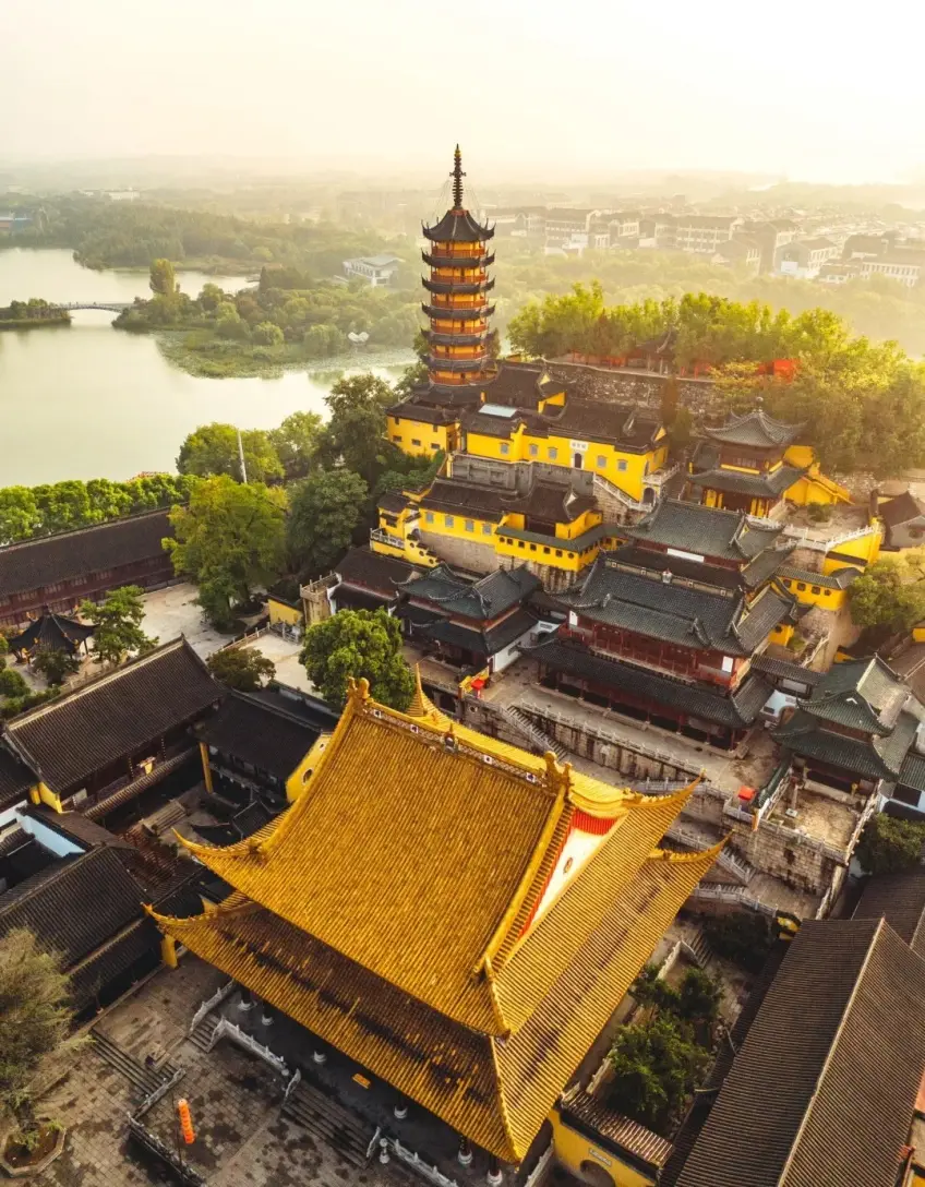 黄昏航拍金山寺黄墙殿宇慈寿塔与湖面