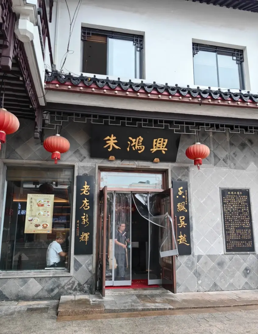朱鴻興白牆金匾紅燈籠老店門頭示意