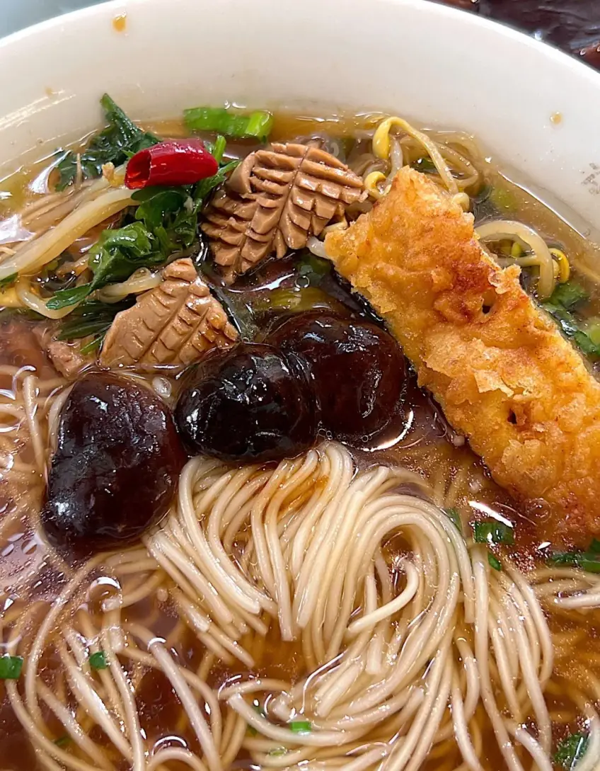 蘑菇腰花與炸澆頭鋪在細麵湯碗上的示意