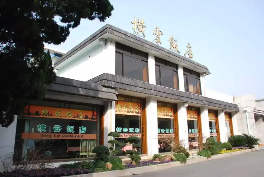 横云饭店二层白墙金字招牌与花坛