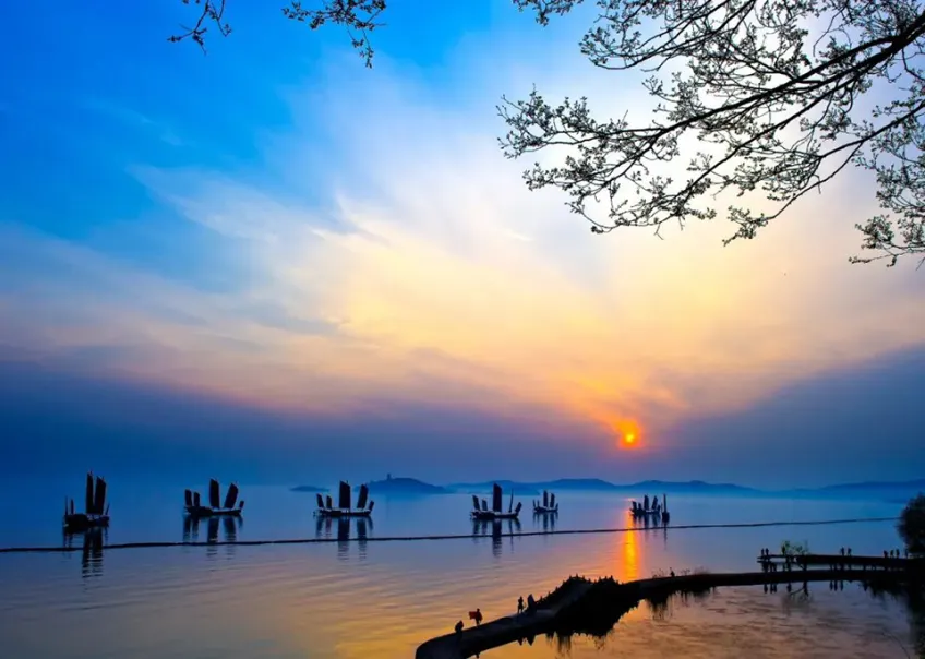 夕阳帆船与栈道人影剪影