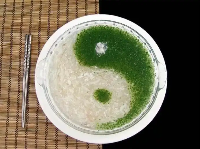 白碗太极形银鱼羹配绿蔬圆点与筷