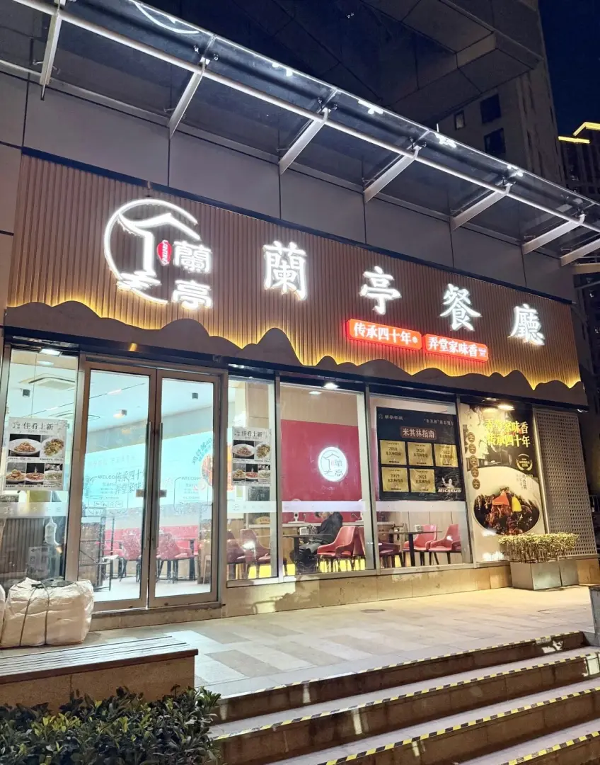 蘭亭餐廳夜景木紋門頭與玻璃門廳示意