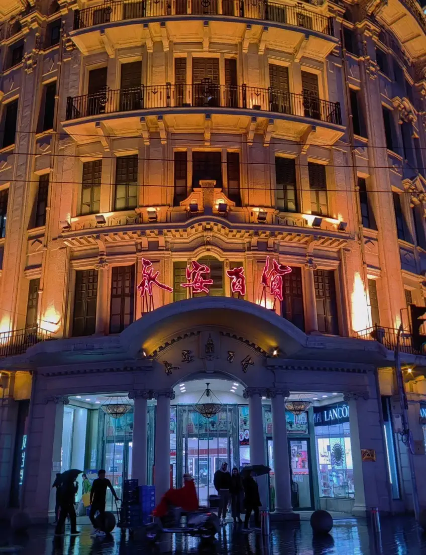永安百货门廊红灯柱廊与行人夜景示意