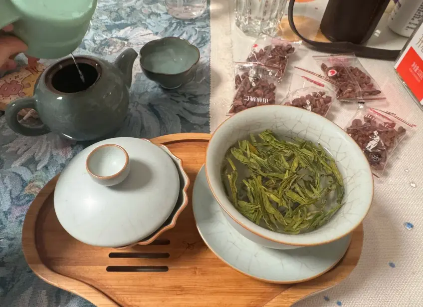 青瓷杯綠茶與紫砂壺注水
