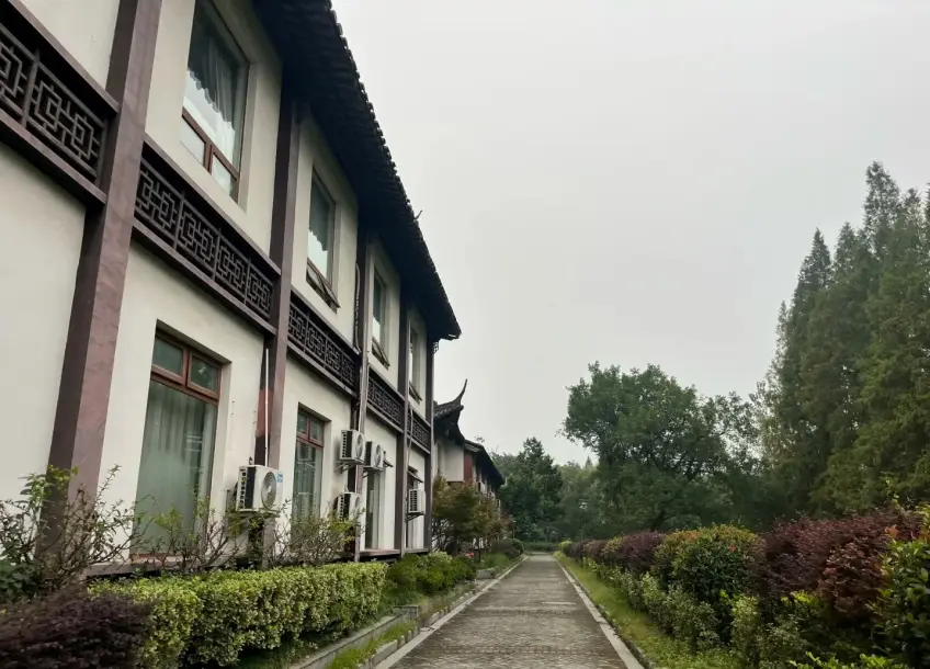 汇璟酒店楼栋旁石径与灌木景色