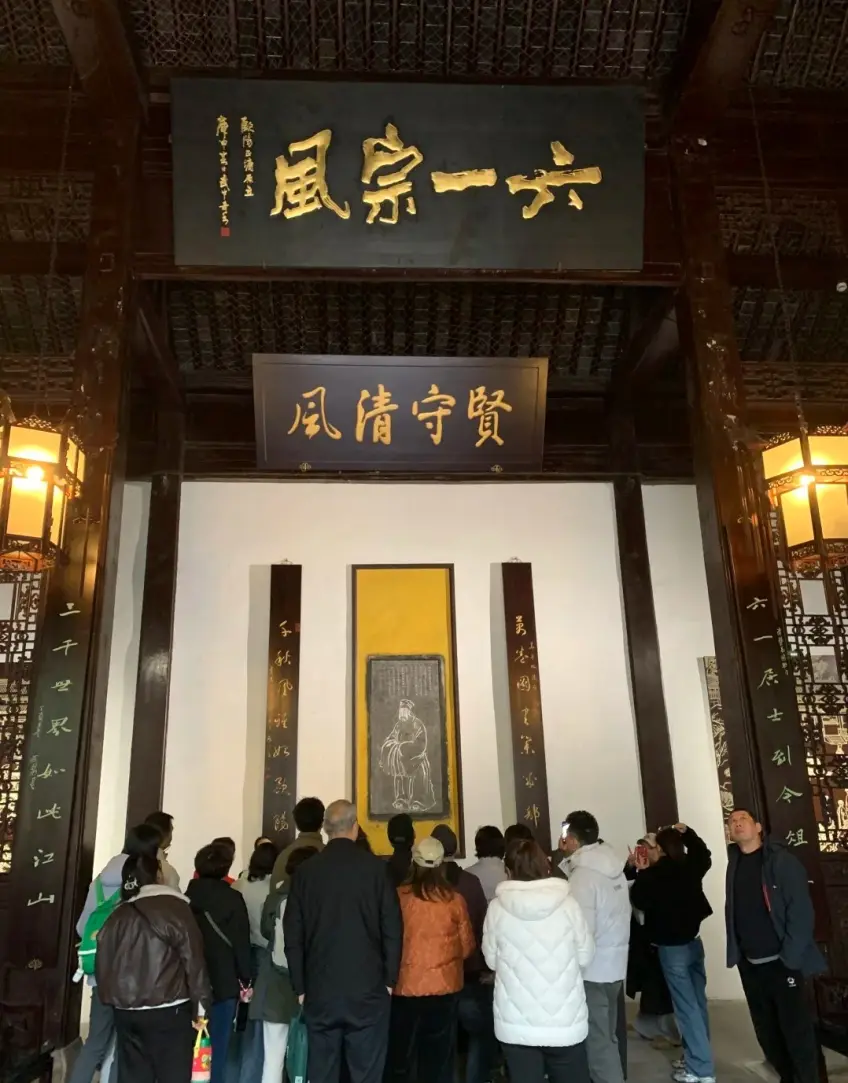欧阳祠六一宗风匾下游客示意