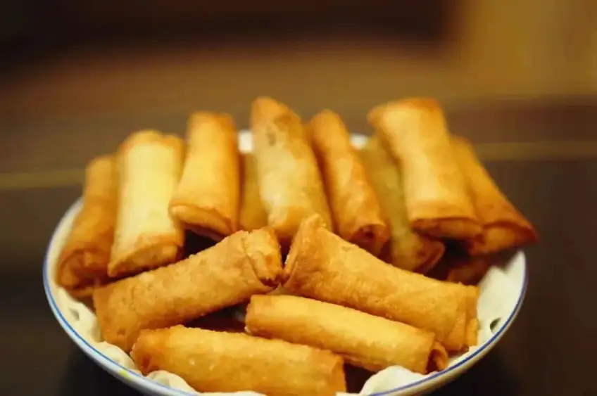 白碗盛裝金黃酥脆炸春捲美食近景