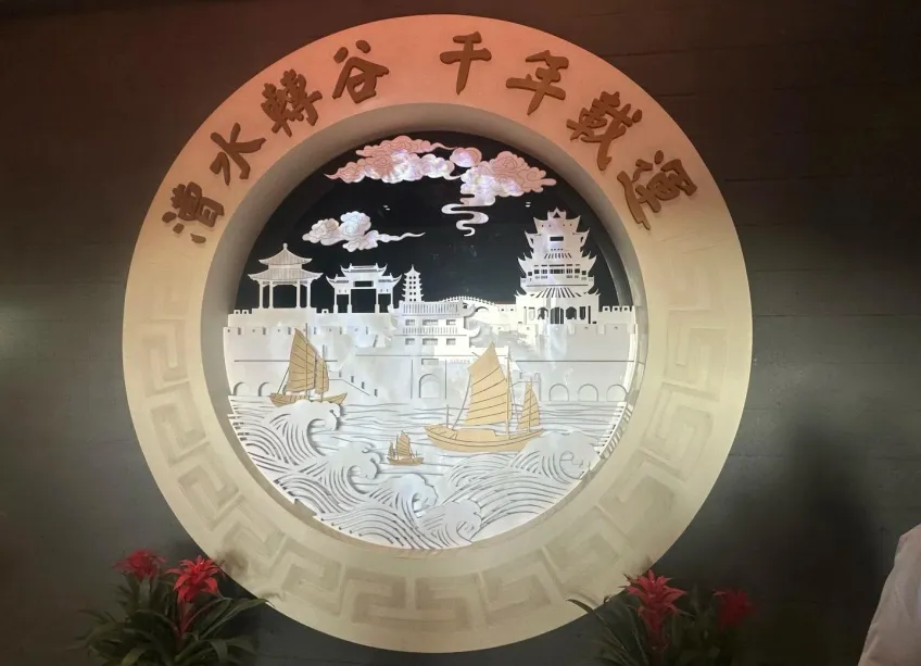 愿景厅圆形镂空边框内的漕船与城郭剪影灯箱，上书「漕水转谷 千年载运」