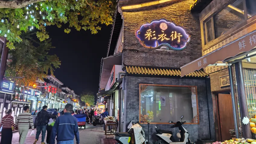 綵衣街灰牆招牌與市井小吃街景橫構圖