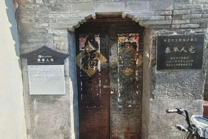 秦举人宅文保碑与木门门楼近景
