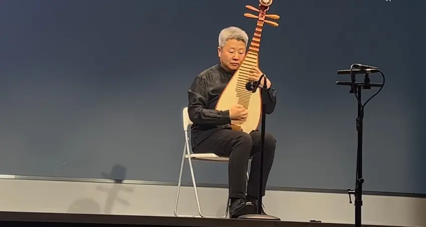 男子黑衣竖抱琵琶舞台演奏