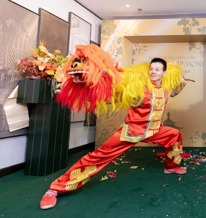 红衣演员举醒狮酒店开业舞台