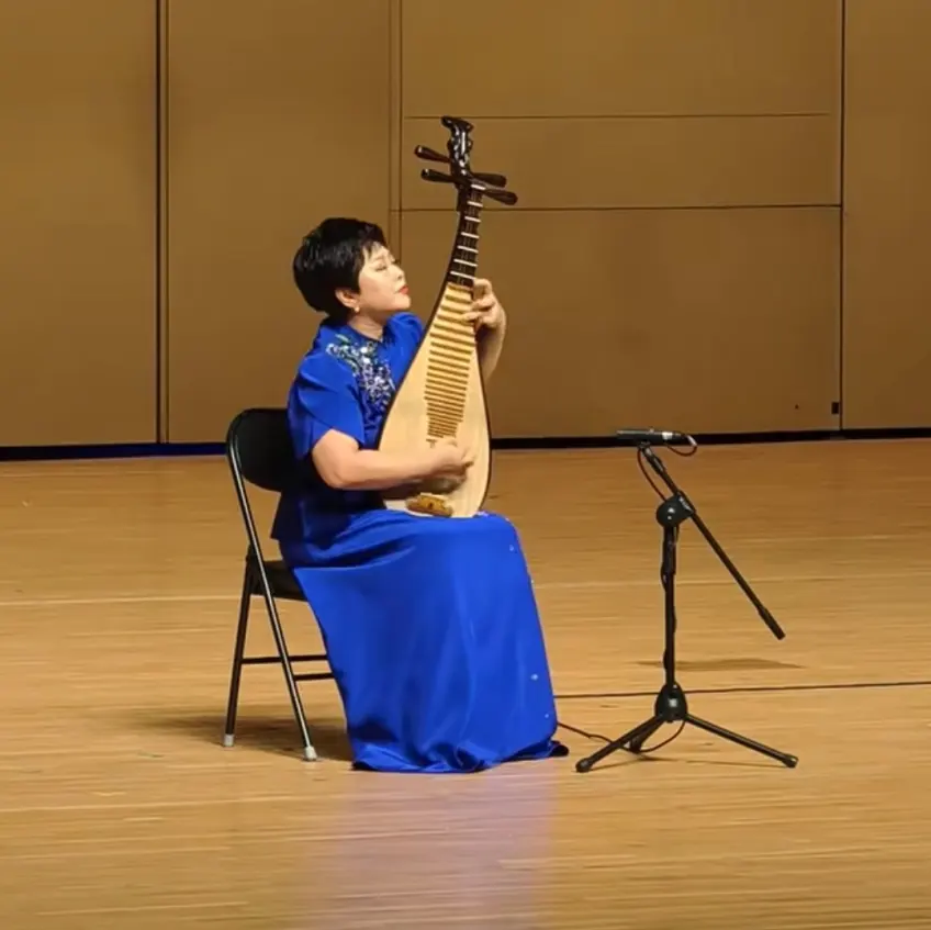 蓝旗袍女子闭目弹琵琶舞台