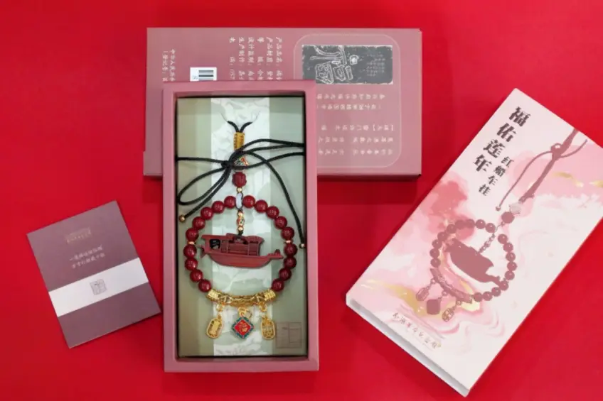 红底上摆放福佑连年红船珠串车挂与礼盒