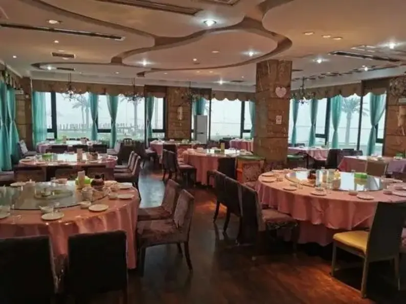 粉桌布圆桌宴会厅窗外可见湖景