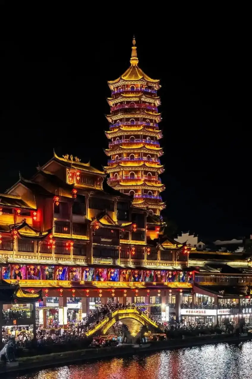 夜色古建灯塔与拱桥金光映水面