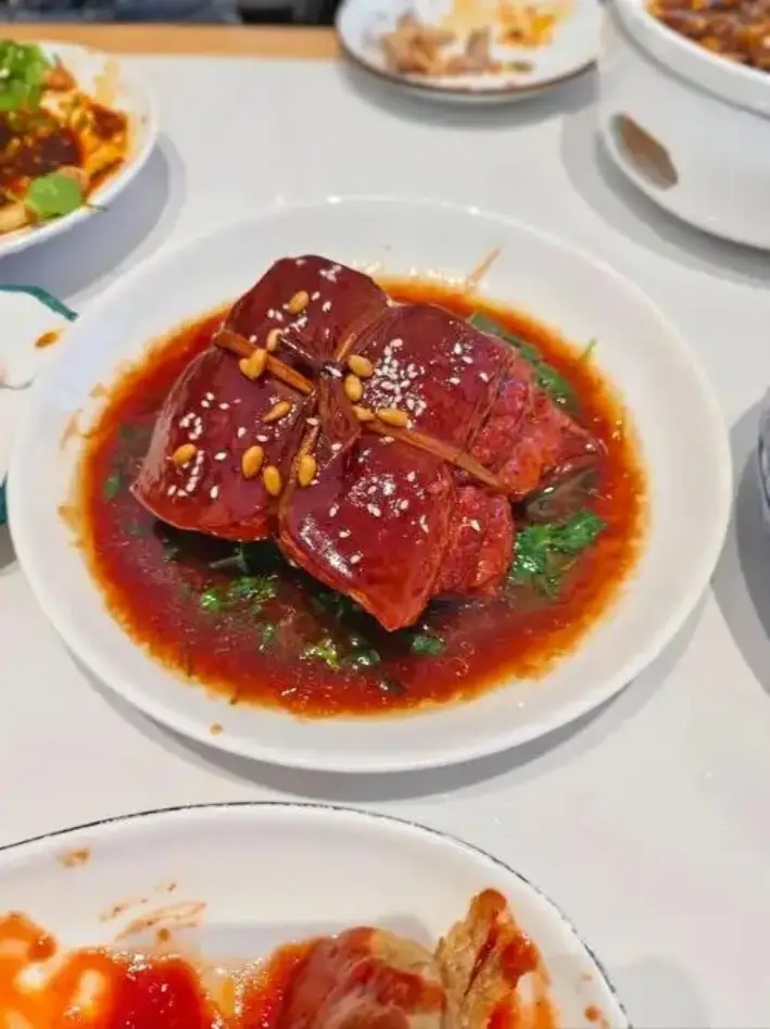 白瓷碗中稻草捆扎的红烧五花肉