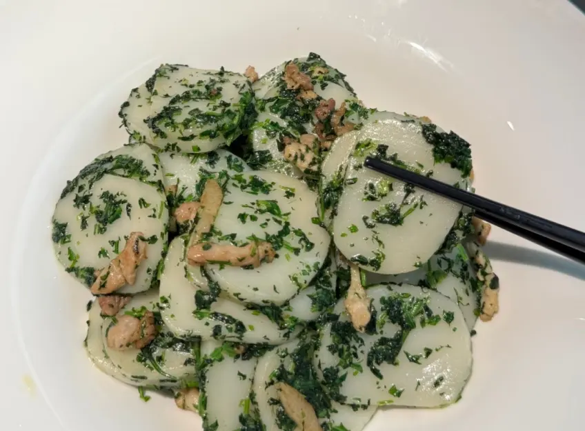荠菜肉丝炒年糕筷子夹起