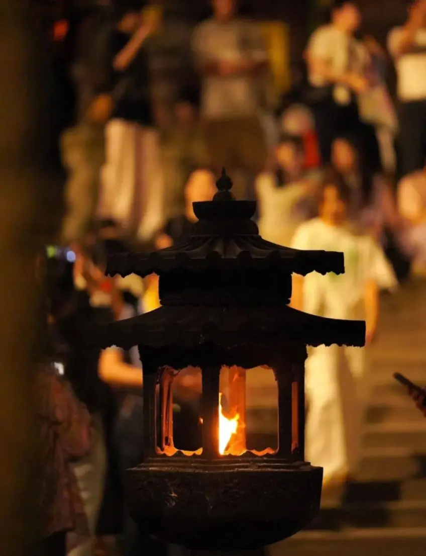 灵隐寺石灯笼夜火与背景游人