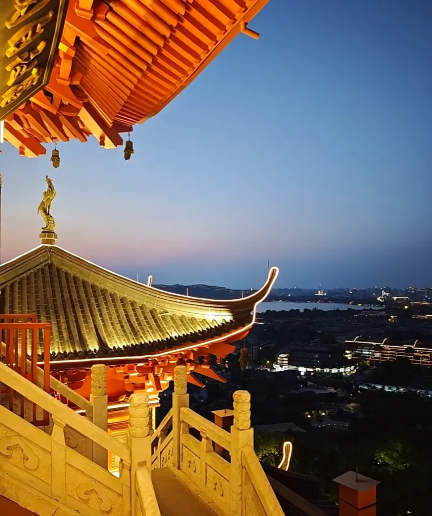城隍阁檐角俯瞰西湖与城市灯火