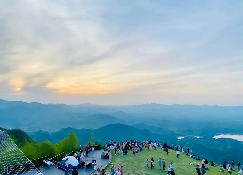 山顶草坪黄昏游客远眺群山湖景